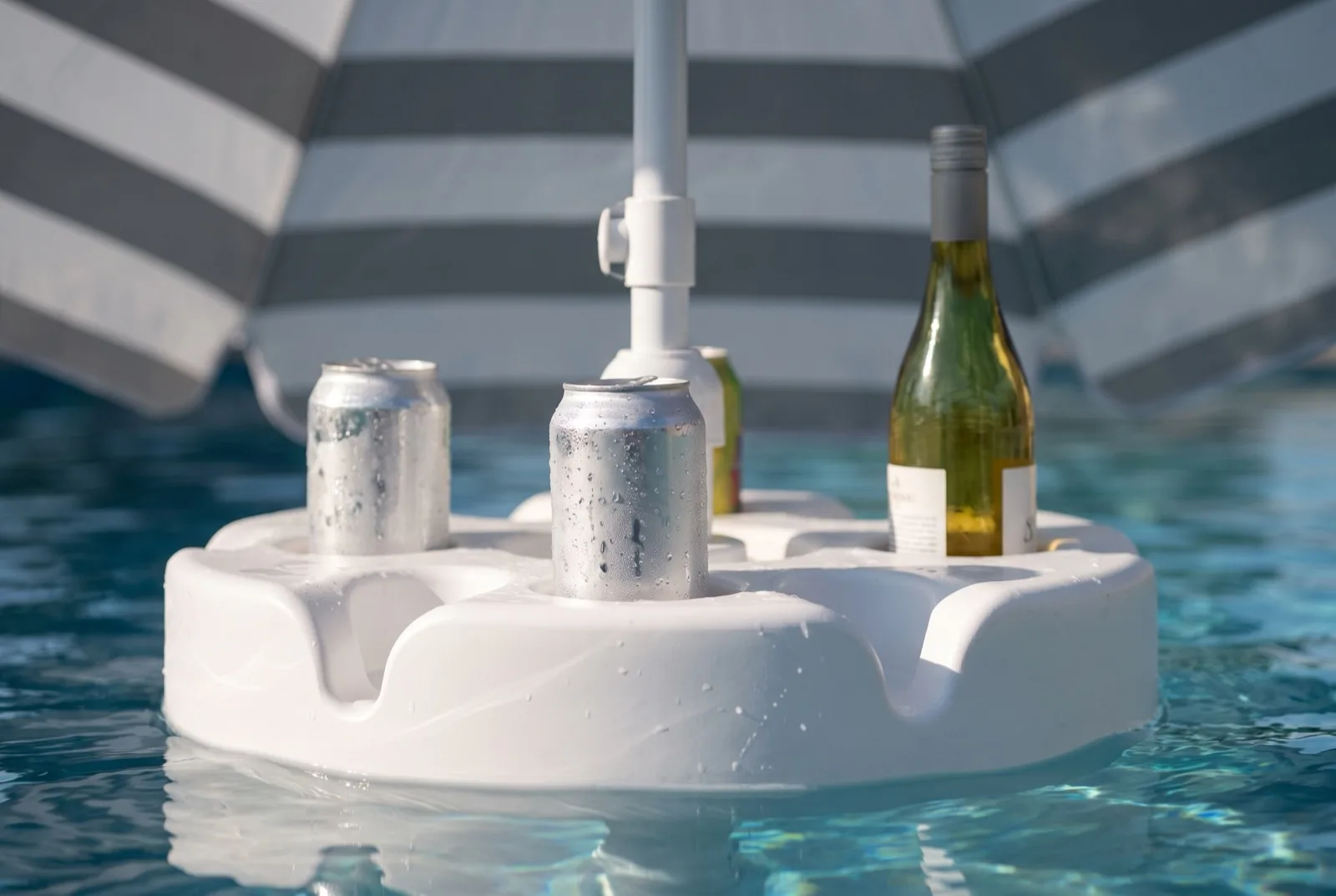 Close-up of cold cans and a bottle standing in the FloatMate table's moulded drink recesses